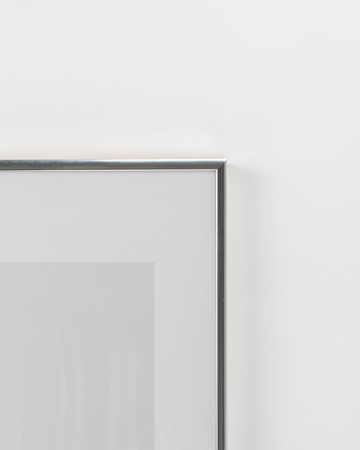 Närbild på hörnet och profilen på silverfärgad aluminiumram 50x70 cm